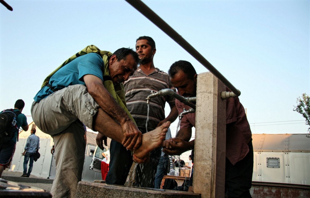 Macedonia, 3 settembre 2015. Migranti si lavano i piedi prima di attraversare il confine con la Serbia. Foto di IFRC su Flickr, licenza CC.
