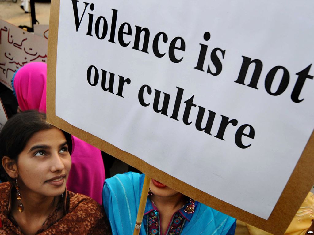 Un'immagine di un'attivista pakistana che contiene un cartello: "La violenza non è la nostra cultura"