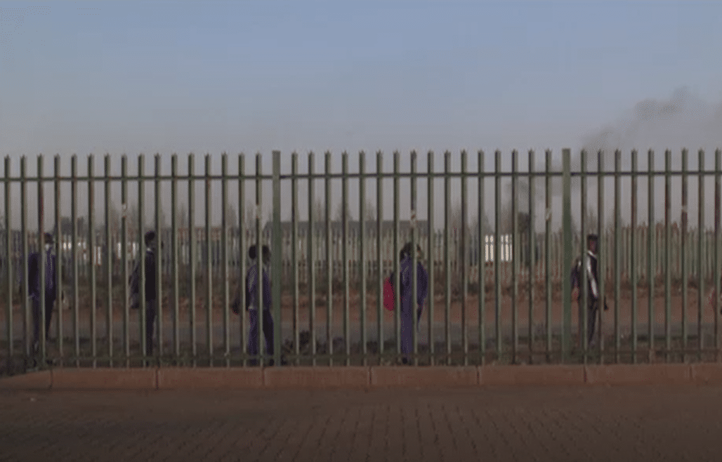 Bambini entrano in una scuola in Sud Africa durante la pandemia